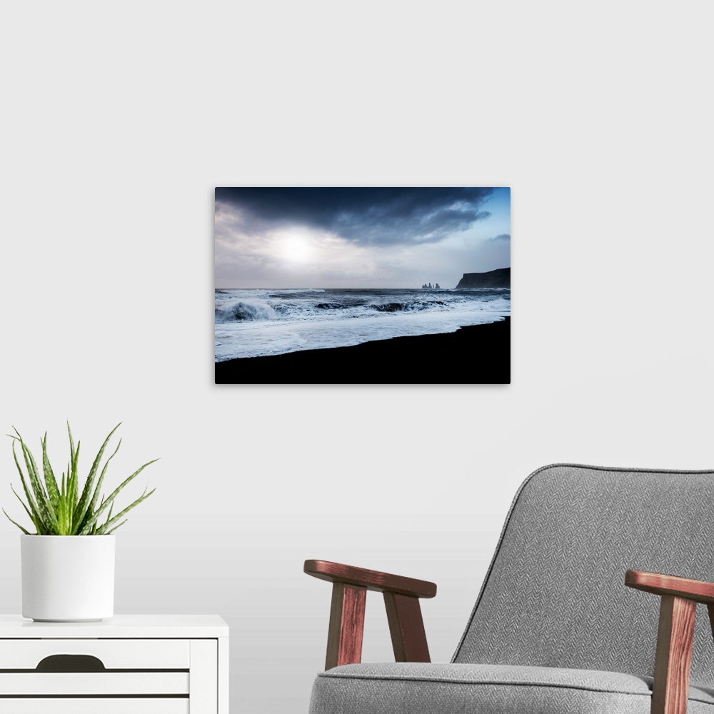 A modern room featuring A photograph of a dark rugged coastline.