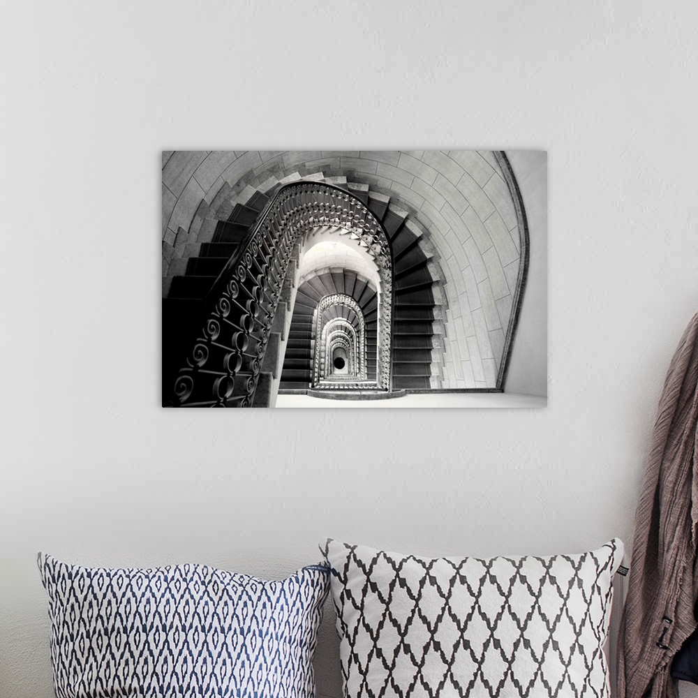 A bohemian room featuring This architectural photograph looks down a historic stairwell lined with tile and iron work banis...