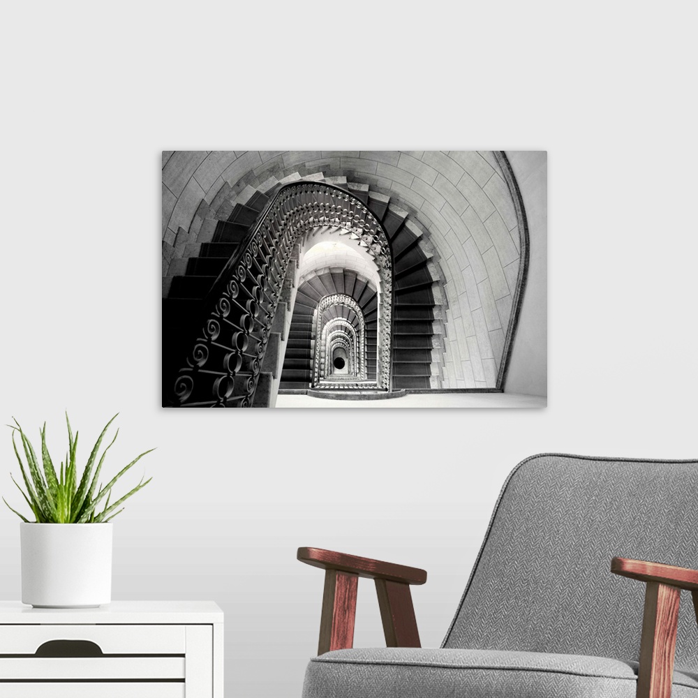 A modern room featuring This architectural photograph looks down a historic stairwell lined with tile and iron work banis...