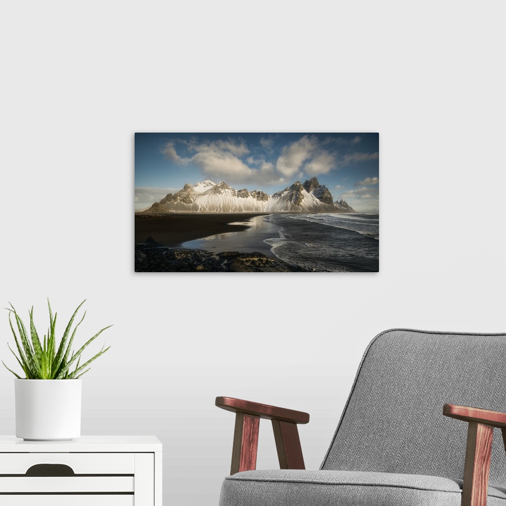 A modern room featuring Snow covered mountain at the edge of the ocean in Iceland.