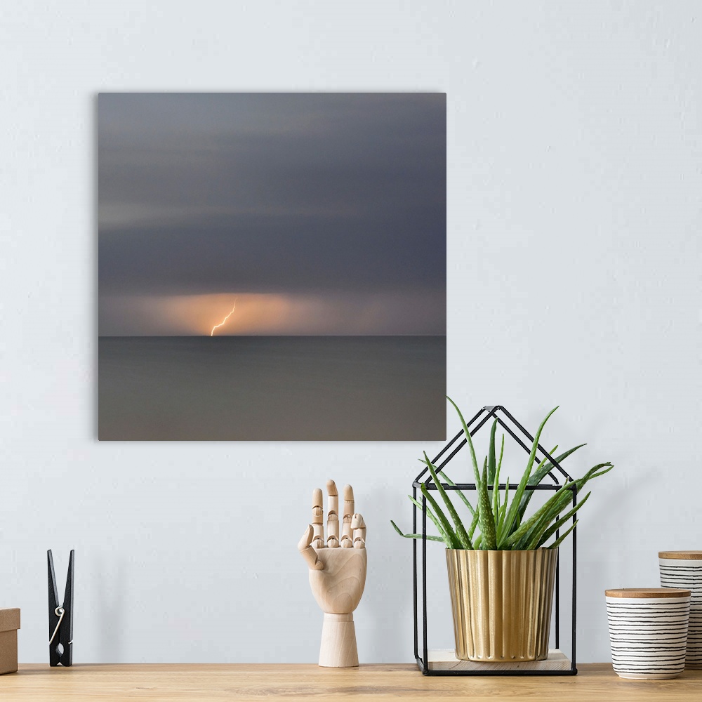 A bohemian room featuring Square picture of a storm flash above a long time exposure sea.