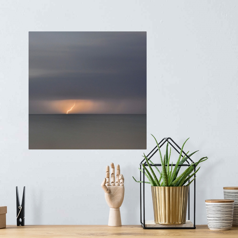 A bohemian room featuring Square picture of a storm flash above a long time exposure sea.