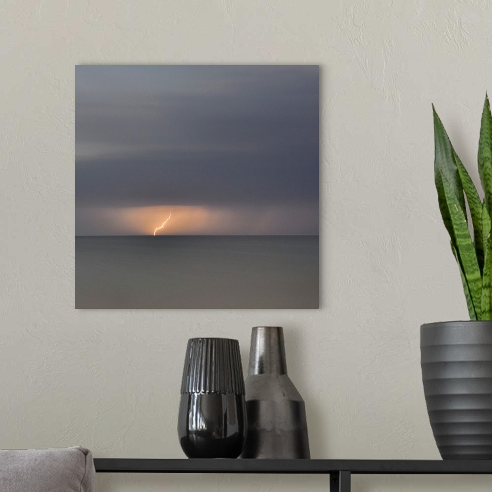 A modern room featuring Square picture of a storm flash above a long time exposure sea.