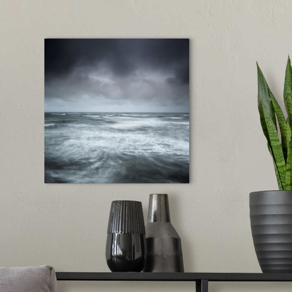 A modern room featuring A stormy seascape, minimalist with swirling waves and a stormy sky in greys, greens, blues and si...