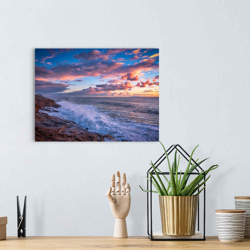 A bohemian room featuring Beautiful photograph of a warm, cloudy sunset over the ocean with crashing waves onto the rocky s...