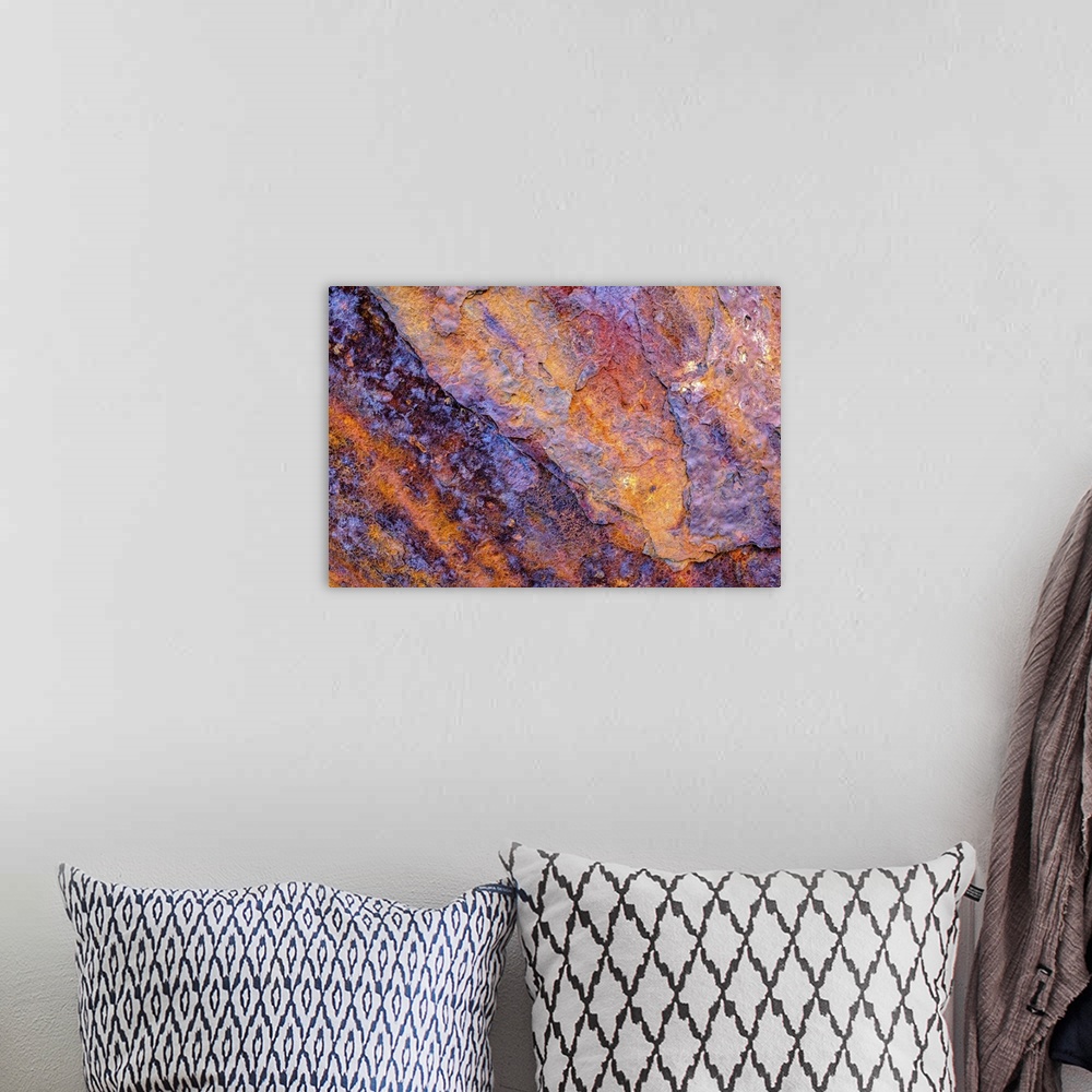 A bohemian room featuring A close-up photograph of a multi-colored rock in purple and orange.
