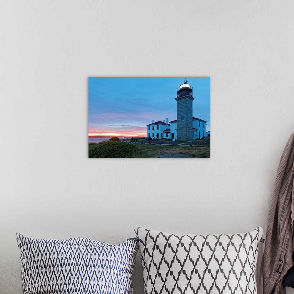 A bohemian room featuring Photograph of lighthouse and building near water's edge under a cloudy sky at dusk.