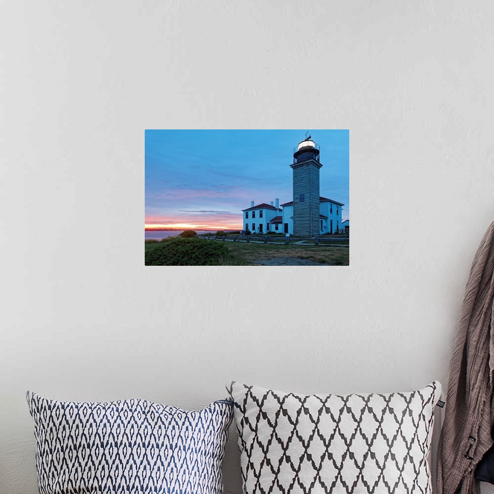 A bohemian room featuring Photograph of lighthouse and building near water's edge under a cloudy sky at dusk.