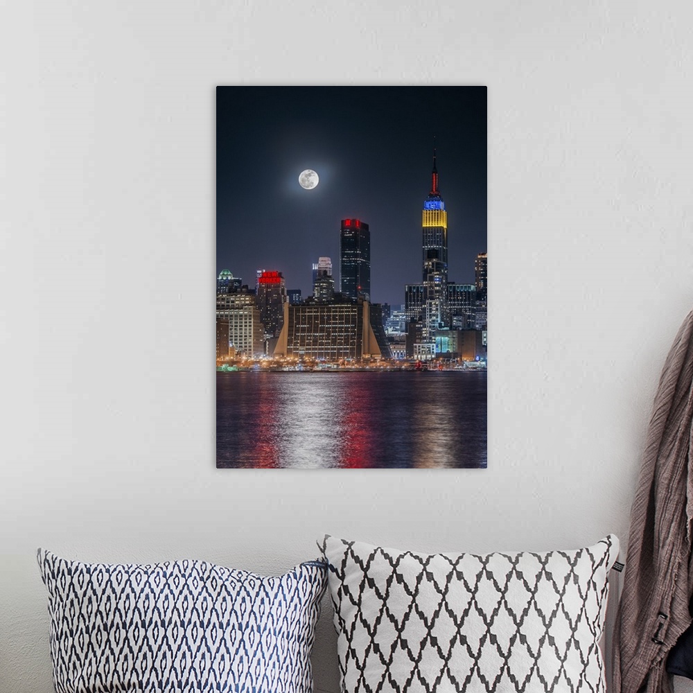A bohemian room featuring Large full moon shining over the Manhattan skyline, reflected in the bay below.