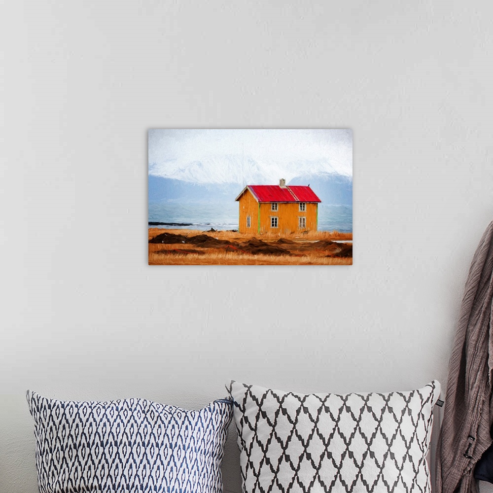 A bohemian room featuring A photograph of a red roofed building in a rugged mountainous landscape.