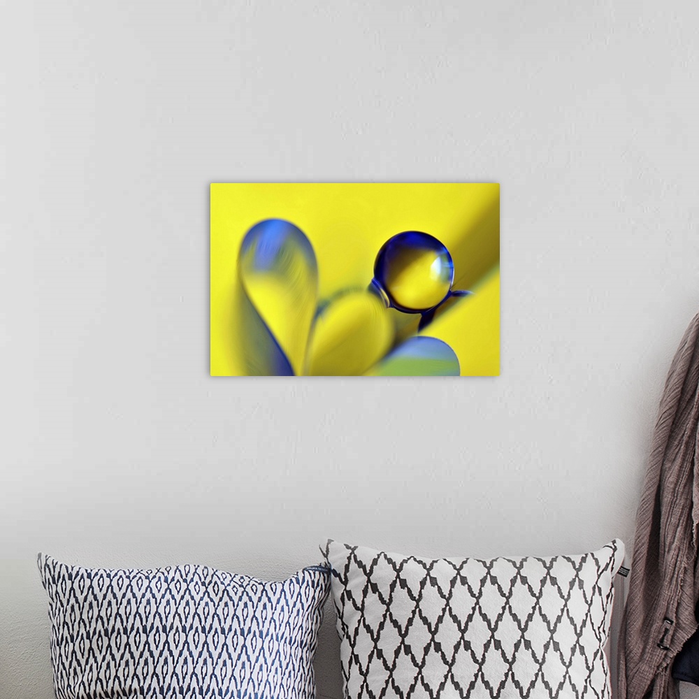 A bohemian room featuring Macro abstract photograph of a water droplet reflecting on a yellow surface with blue ribbon-like...