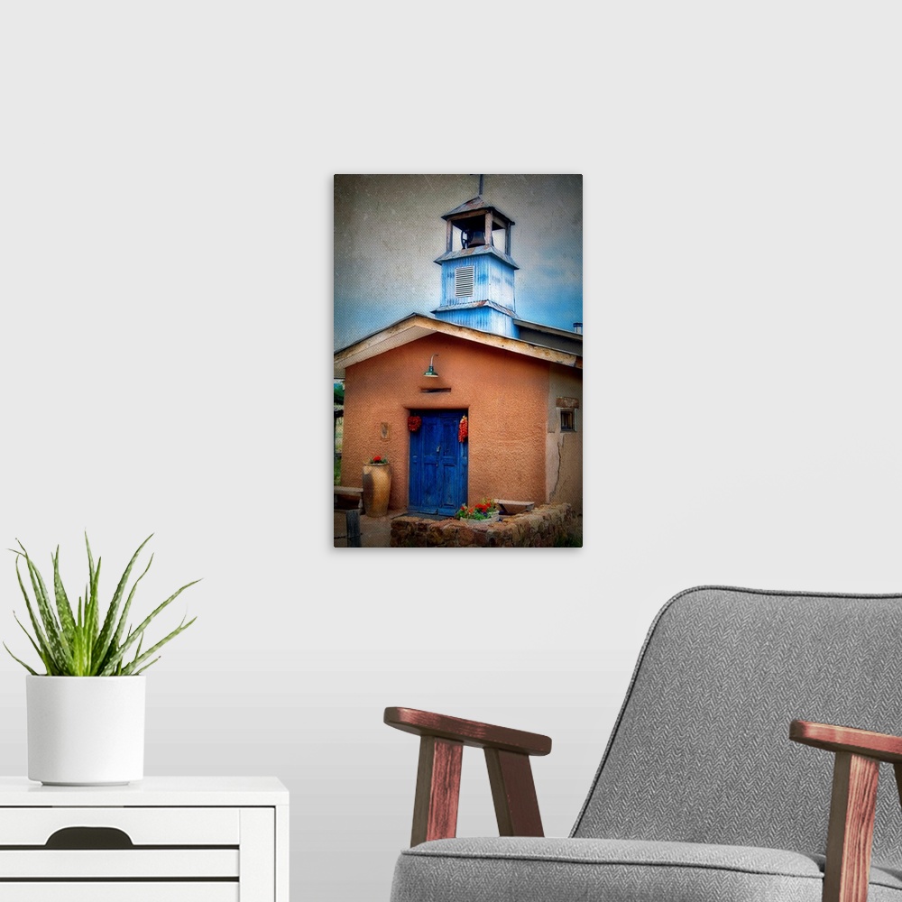 A modern room featuring frontal view of a small Adobe Chapel, Truchas, New Mexico.
