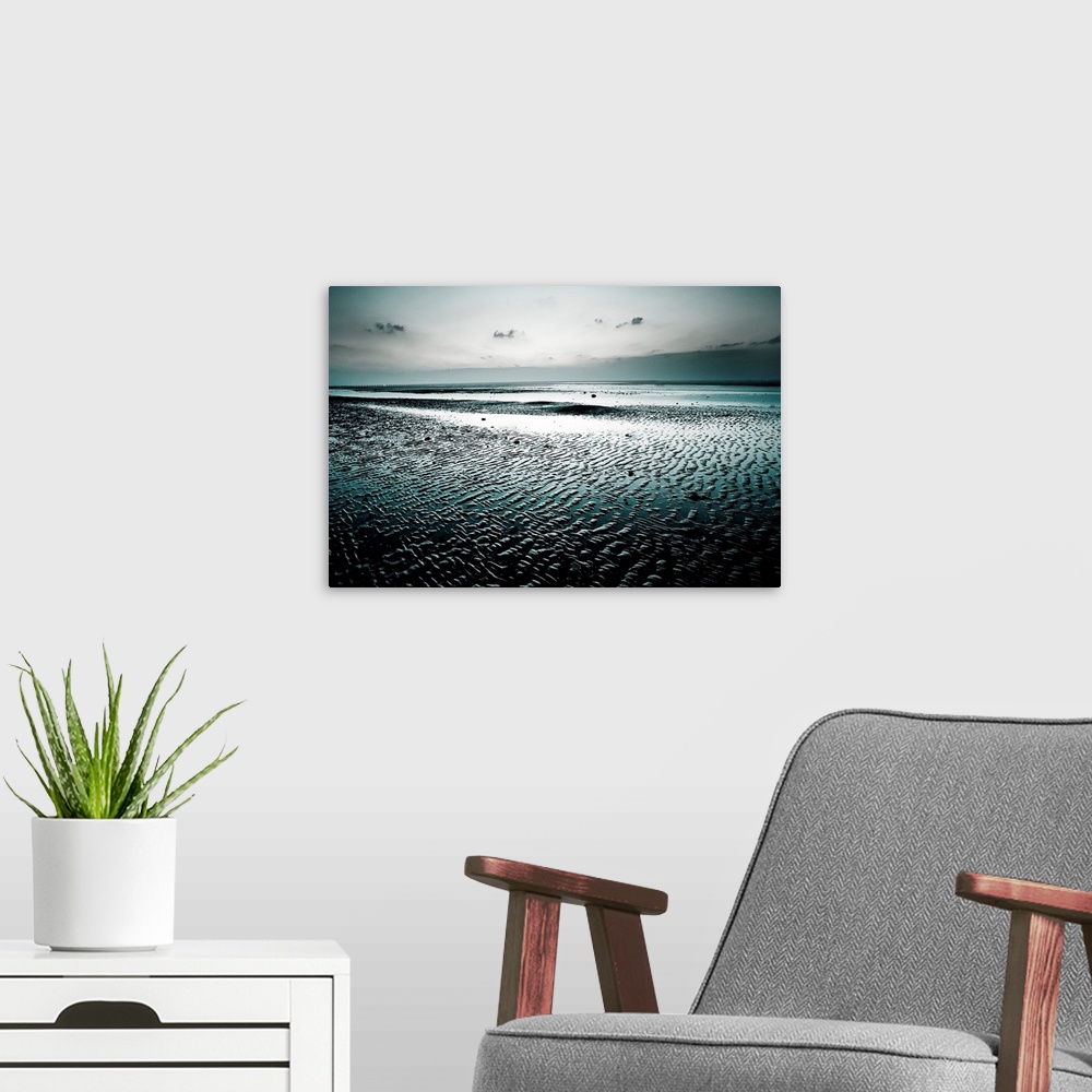A modern room featuring Big, landscape, fine art photograph of a wet, empty beach, surrounded by darkness beneath a gray ...