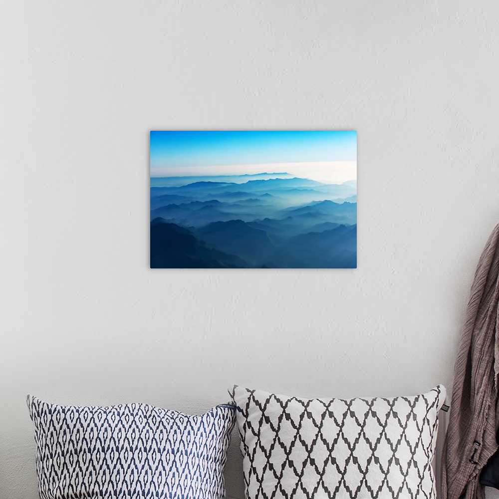 A bohemian room featuring Mountains of Laos seen from the sky in a bluish atmosphere at sunrise