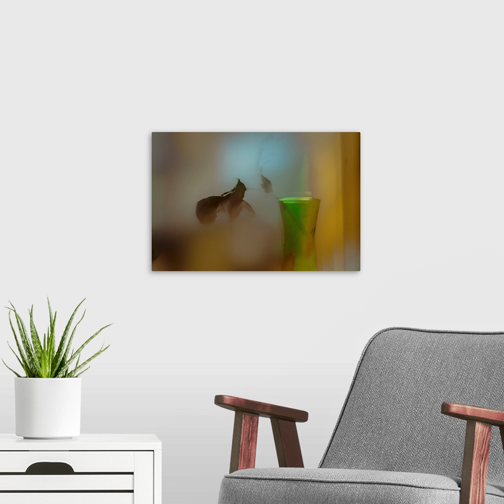 A modern room featuring A soft of focus photo of a dying plant inside a vase.