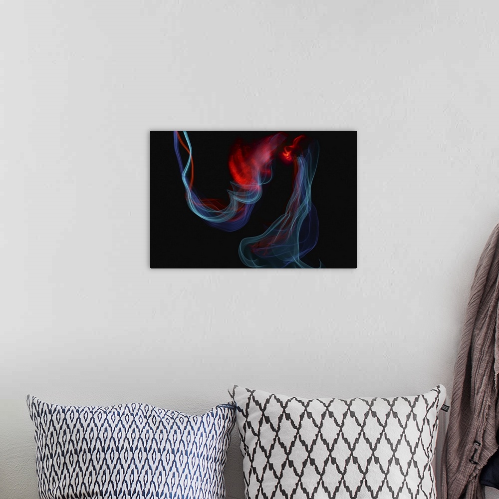 A bohemian room featuring Abstract image created by trailing blue and red lights, resembling wisps of smoke.