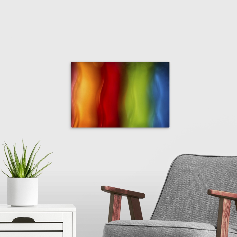 A modern room featuring Abstract photograph in orange, red, green, and blue vertical layers.