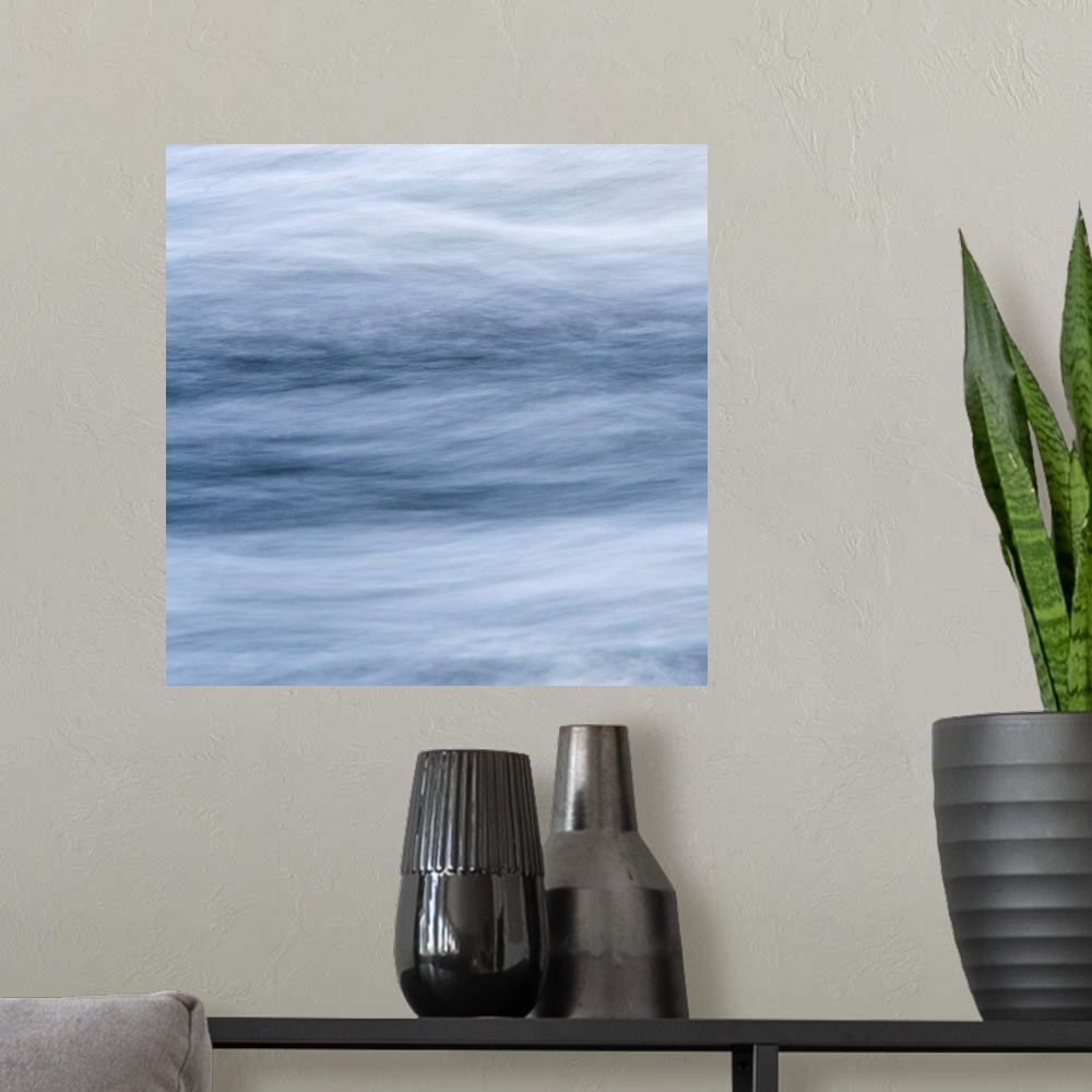 A modern room featuring An abstract piece of artwork with streams of soft clouds running horizontally across the print.