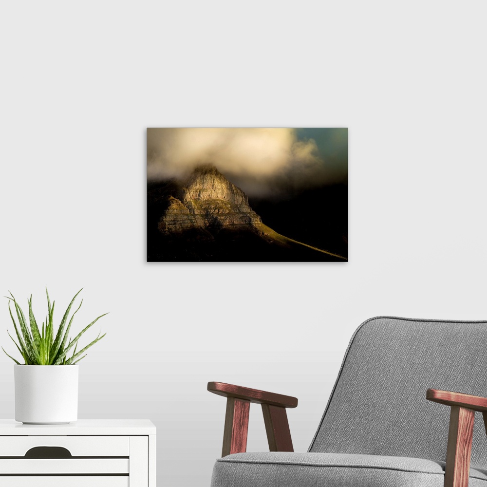A modern room featuring A photograph of clouds rolling over a mountain peak.