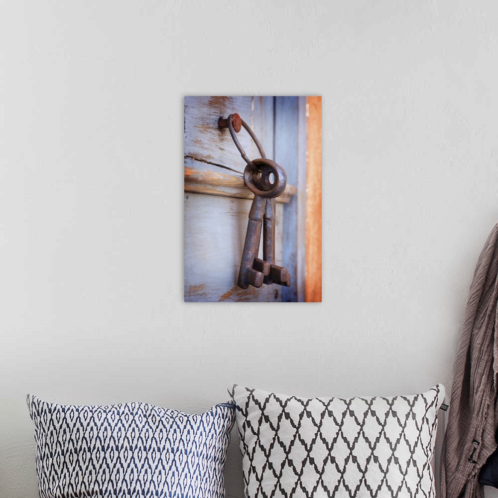 A bohemian room featuring A photograph of a set of large rustic keys hanging on a wooden door.