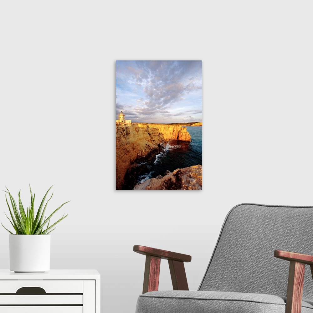 A modern room featuring Photo on canvas of a lighthouse on top of a cliff overlooking the ocean.