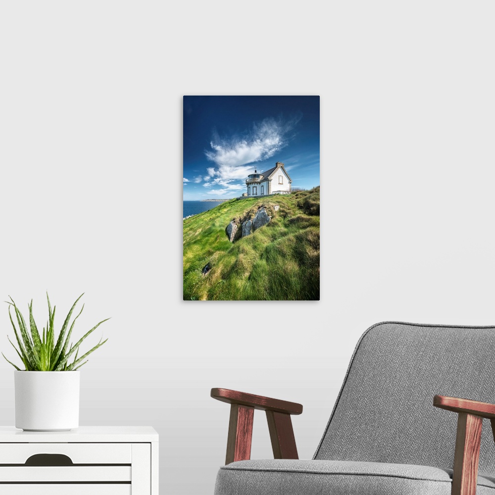 A modern room featuring A photograph of a cozy cottage sitting on a hilltop overlooking an ocean.