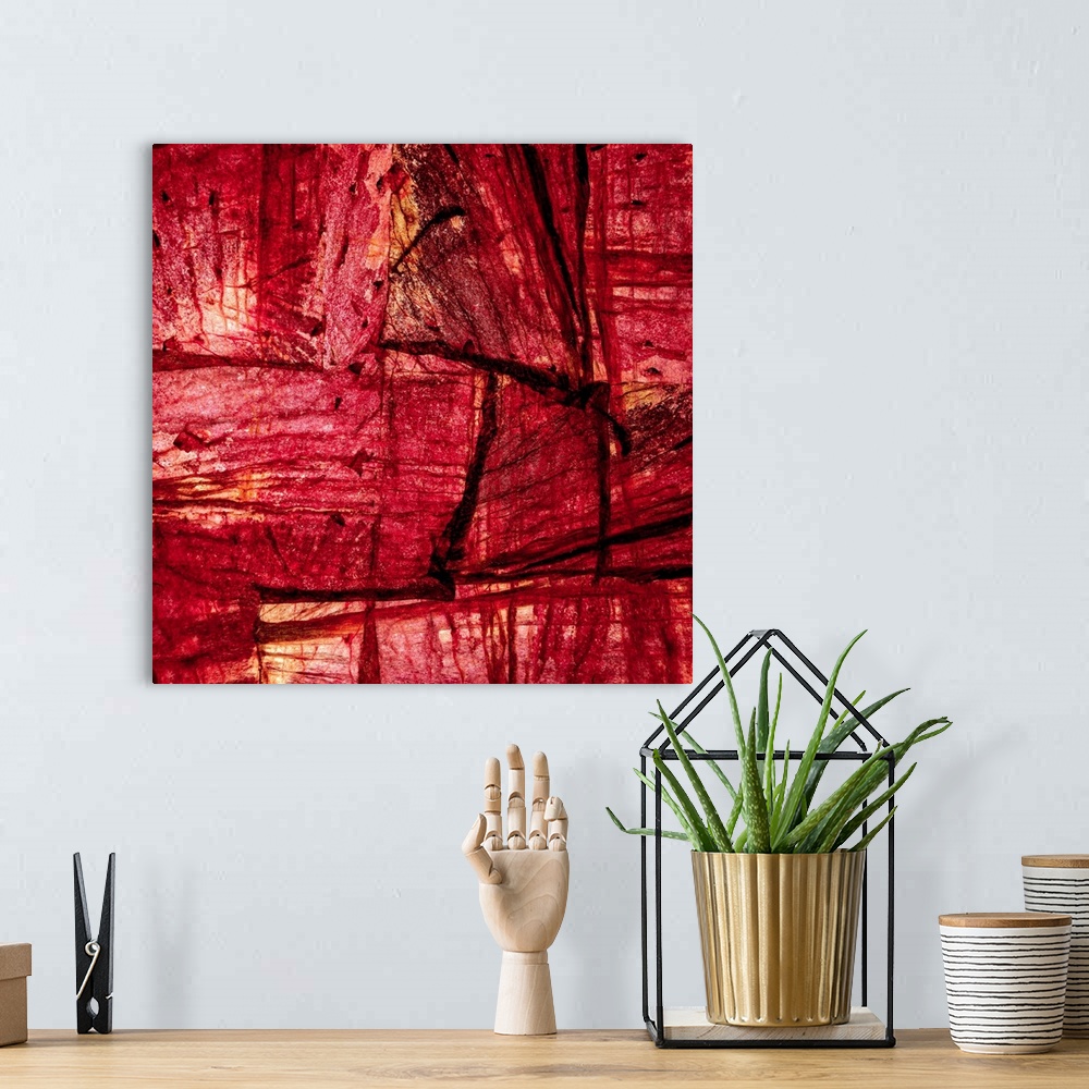 A bohemian room featuring Square abstract art with sections of wood placed together in shades of red and orange.