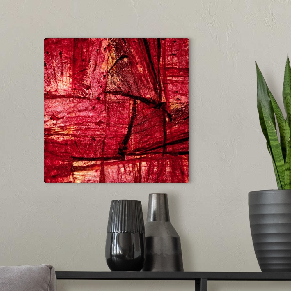 A modern room featuring Square abstract art with sections of wood placed together in shades of red and orange.