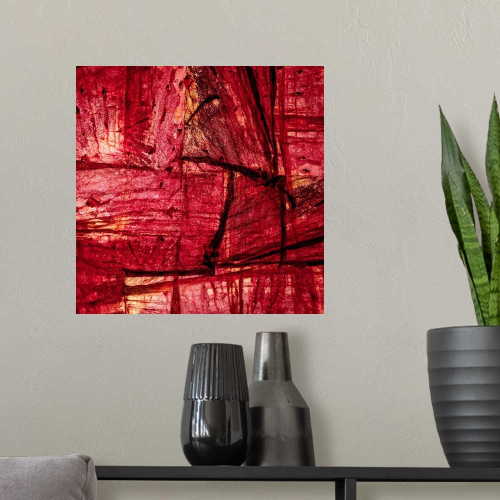 A modern room featuring Square abstract art with sections of wood placed together in shades of red and orange.