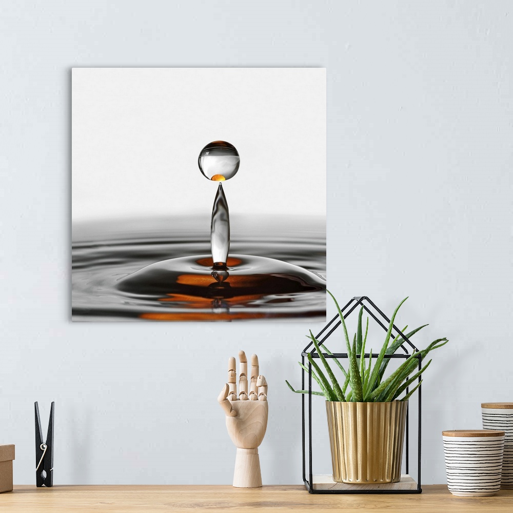 A bohemian room featuring A photograph of a water droplet rising up from a splash.