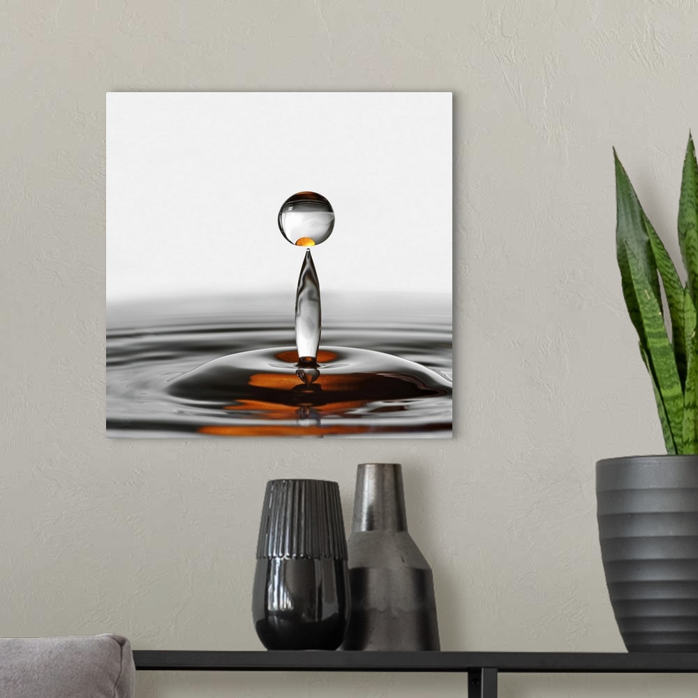 A modern room featuring A photograph of a water droplet rising up from a splash.