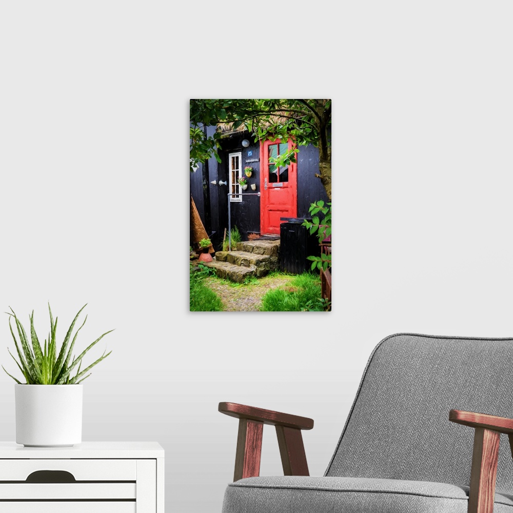 A modern room featuring A black painted house with a bright red door and stone steps.