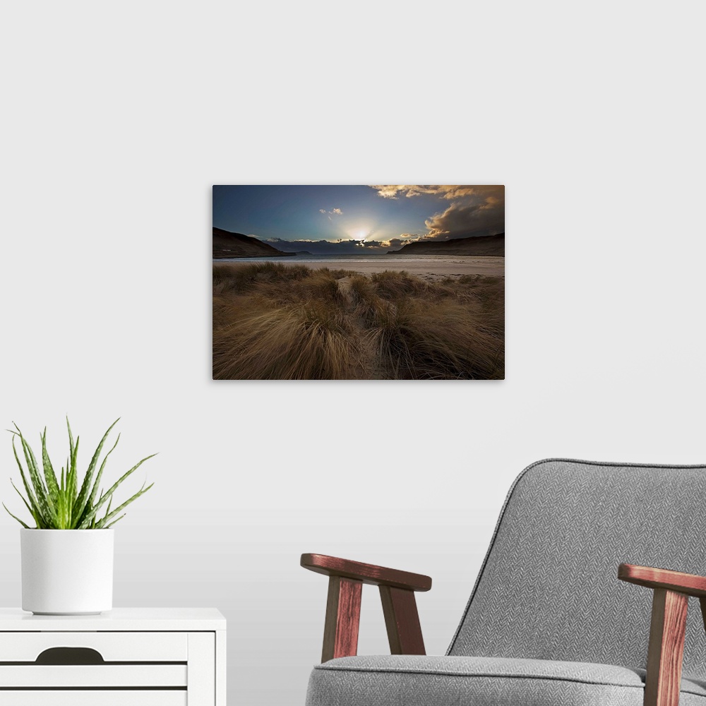 A modern room featuring A dramatic seascape sunrise with crepuscular God's Rays from behind clouds with a blue sky and wi...