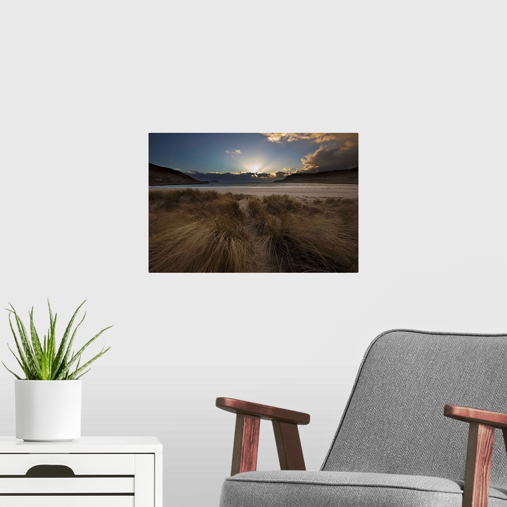 A modern room featuring A dramatic seascape sunrise with crepuscular God's Rays from behind clouds with a blue sky and wi...