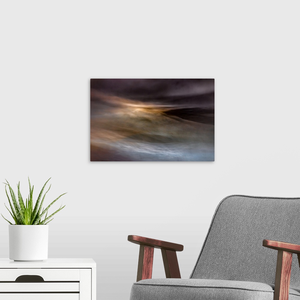 A modern room featuring An impressionistic dreamy blurred Turneresque seascape of swirling water and sky in blues, orange...