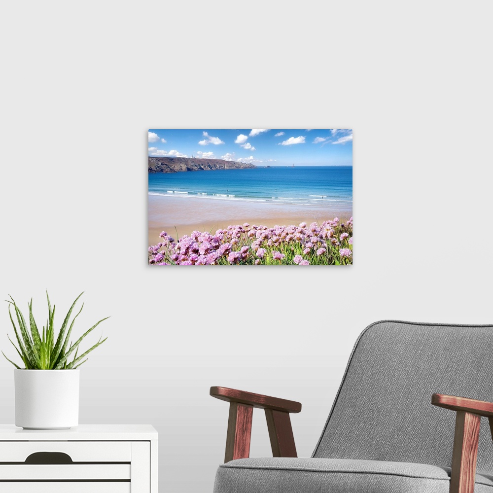 A modern room featuring Pink flowers on the coast of St. Lunaire in northern France, overlooking a turquoise ocean.