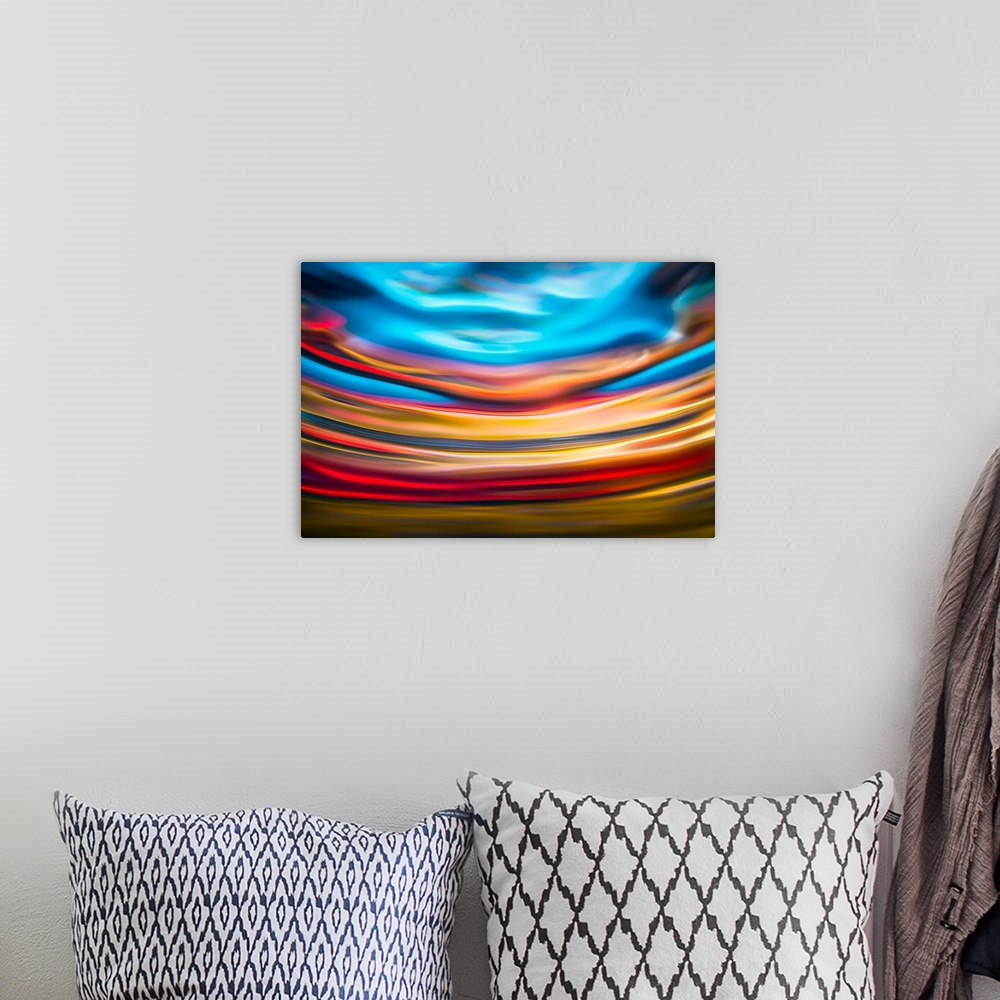 A bohemian room featuring Abstract photograph with arched lines in hues of yellow, red, and blue.