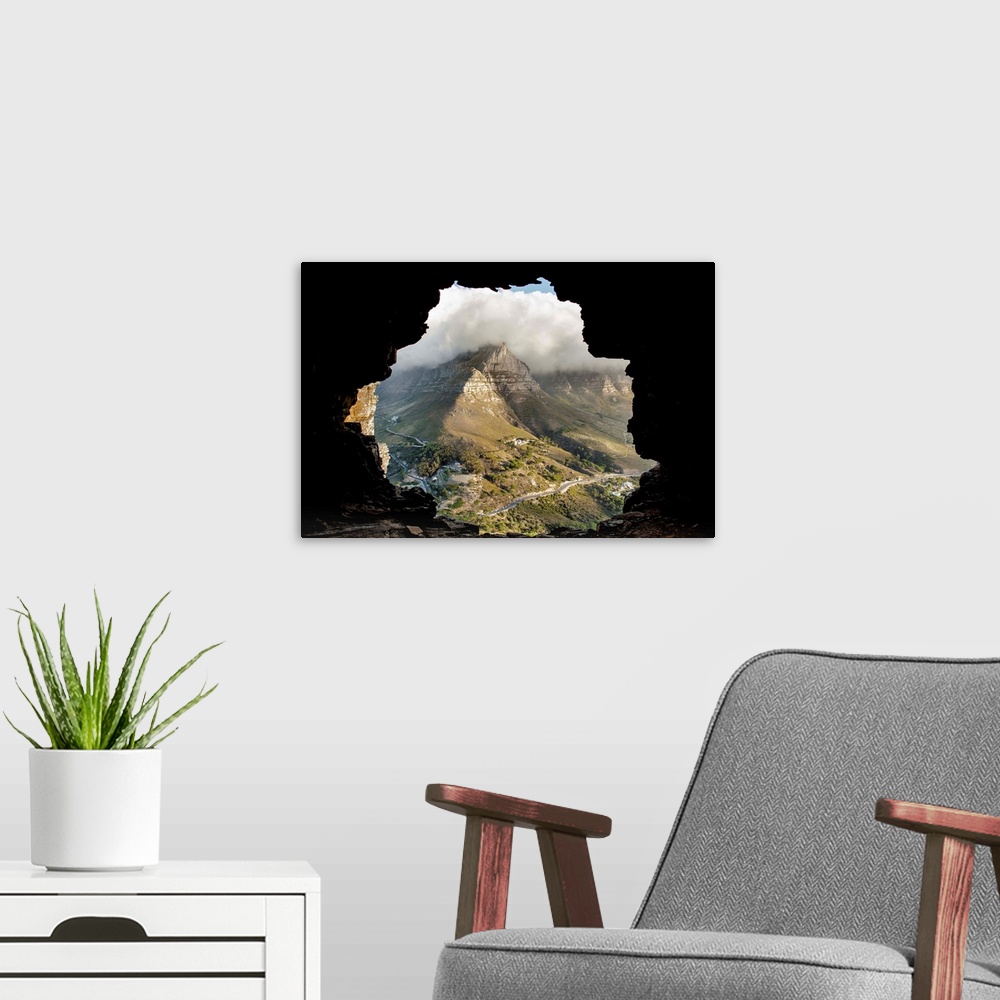 A modern room featuring A key hole view of a mountain from the inside of a cave.