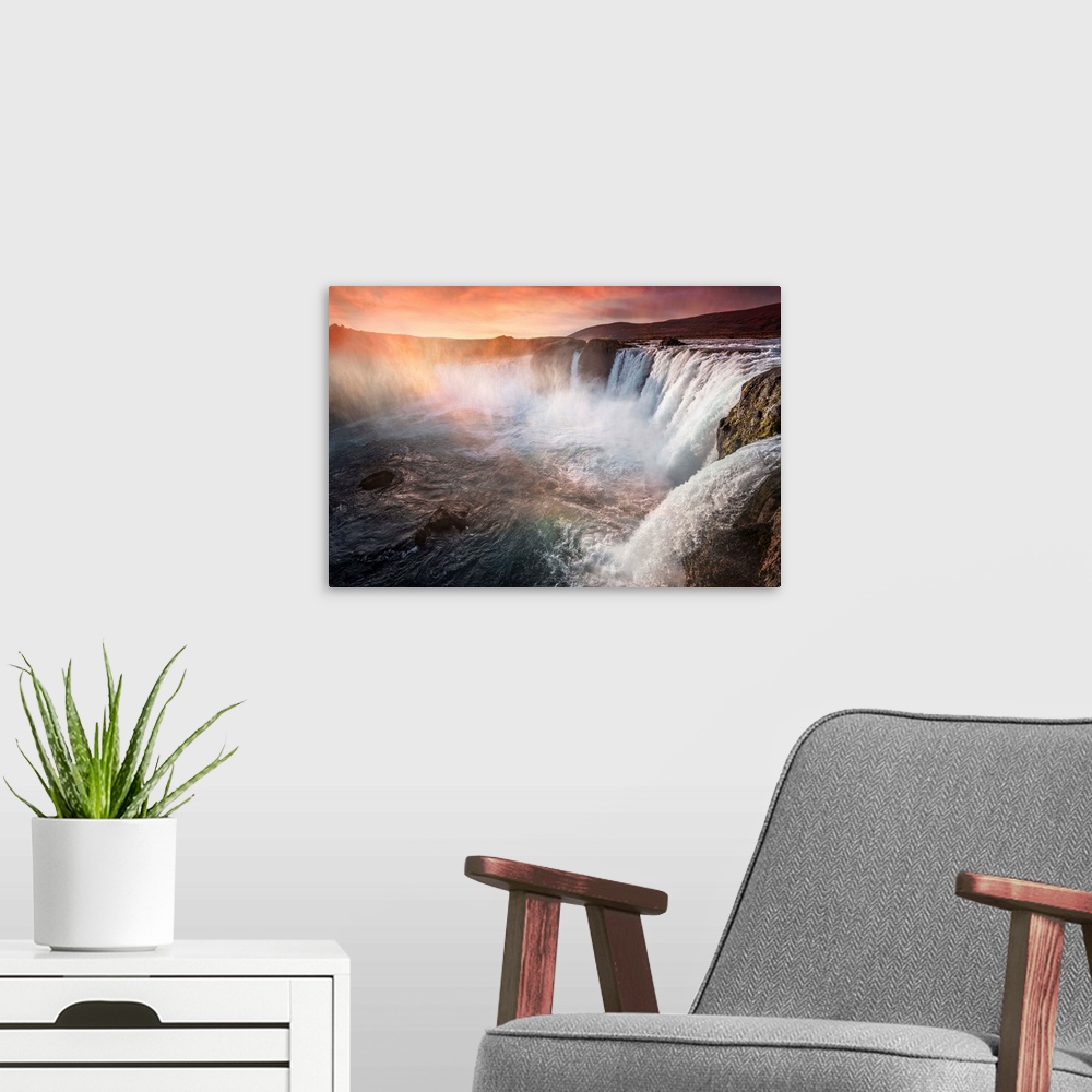 A modern room featuring Fine art photograph of a large series of waterfalls with orange sunlight shining down.