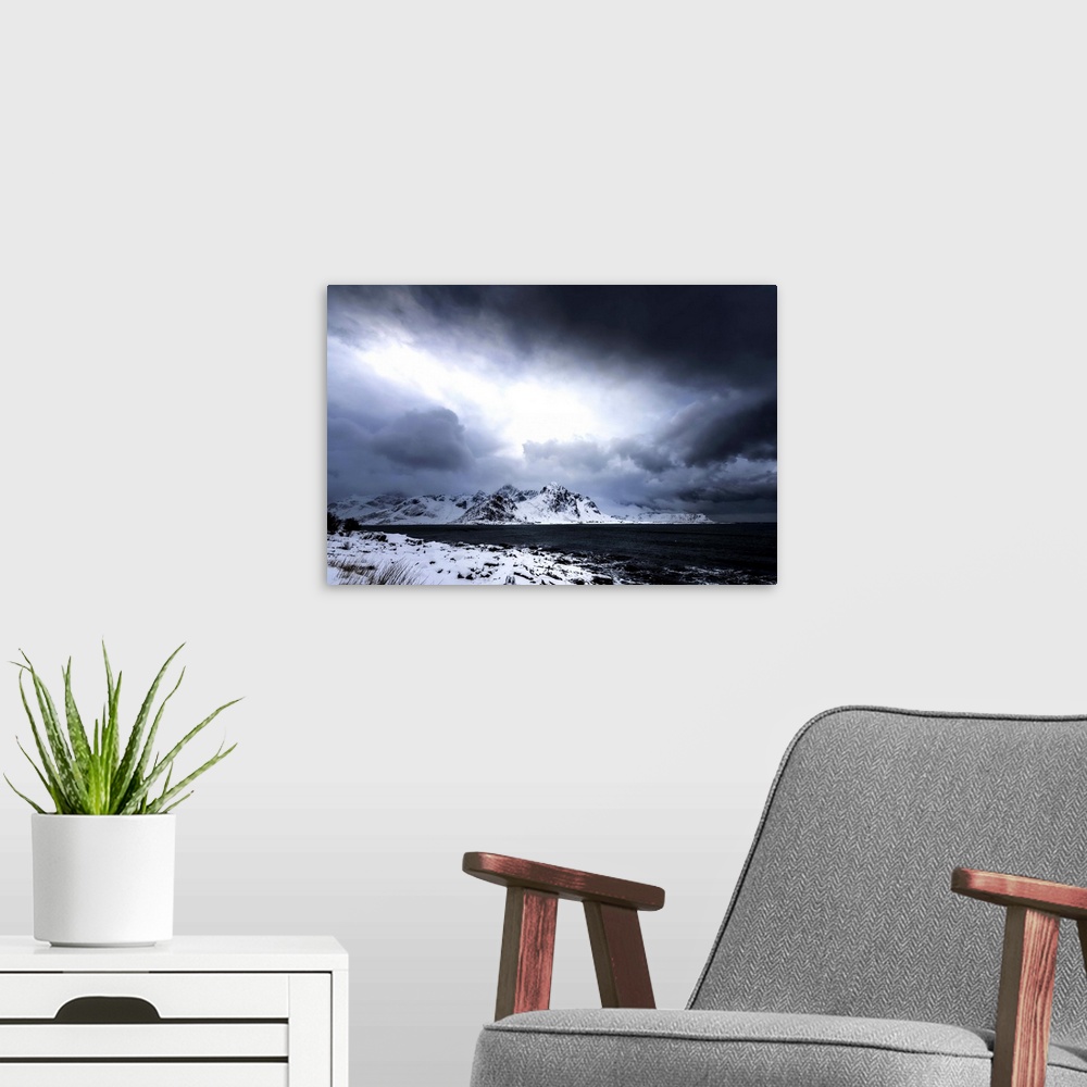 A modern room featuring A photograph of a mountain range seen from across a lake in winter.