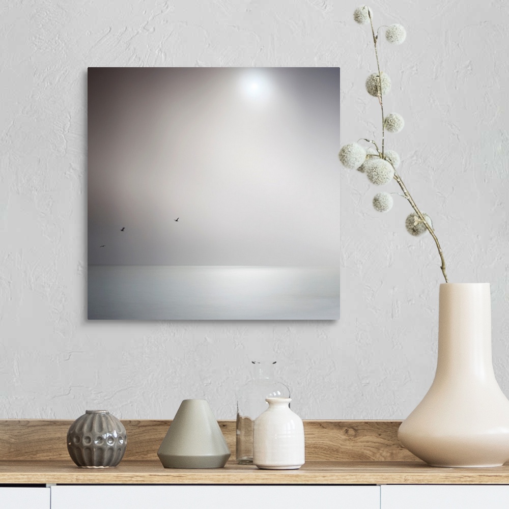A farmhouse room featuring Square photo on canvas of the sun shining down on an ocean with three birds flying above it.