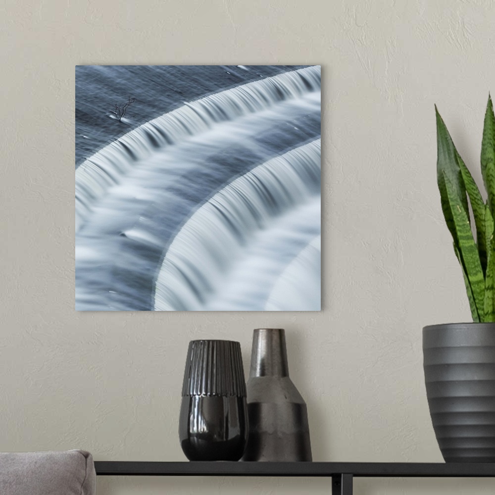 A modern room featuring A photograph of rushing motion blurred flowing over steps.
