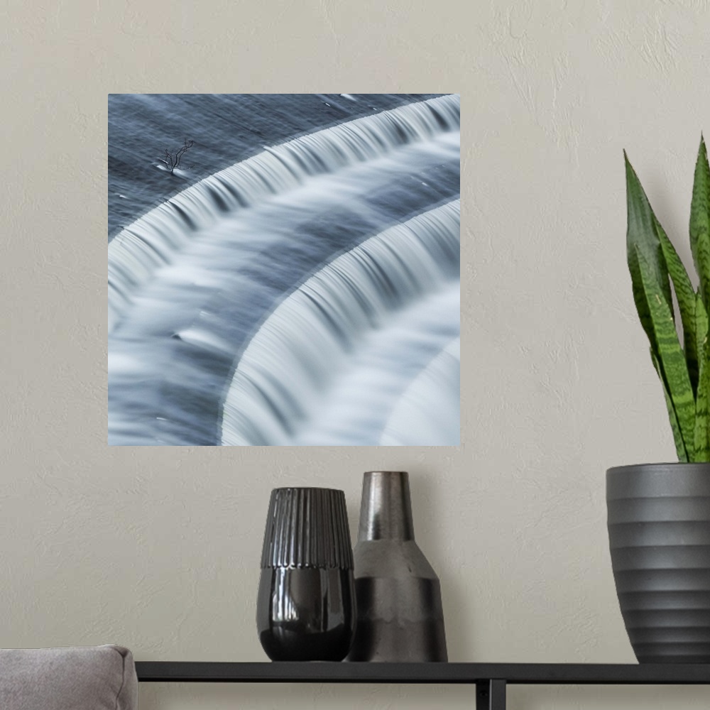 A modern room featuring A photograph of rushing motion blurred flowing over steps.