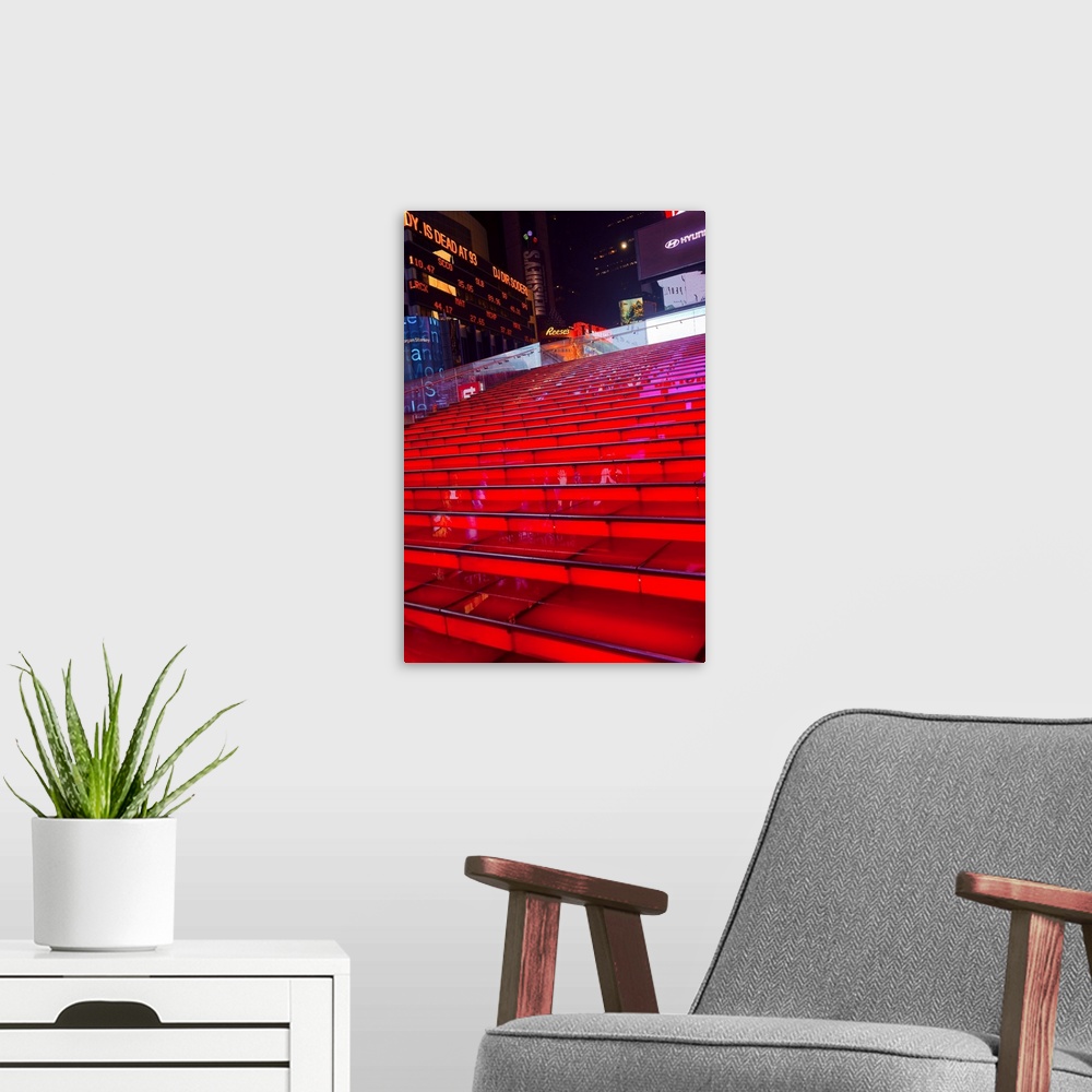 A modern room featuring Illuminated red steps outside of Times Square at night, New York City.