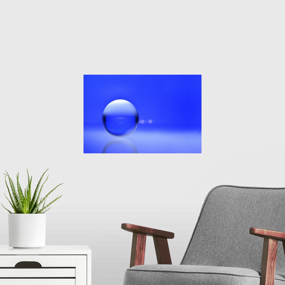 A modern room featuring A macro photograph of a water droplet on a blue surface.
