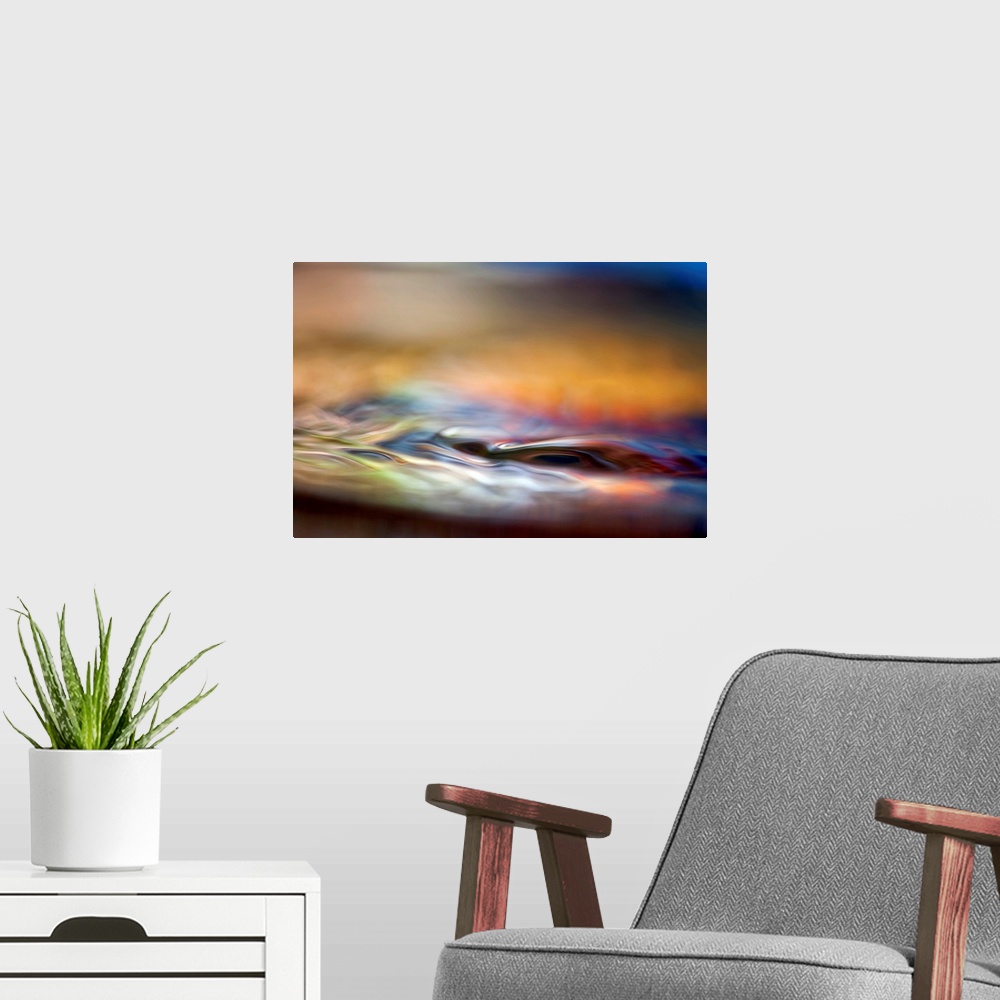 A modern room featuring Abstract photograph of smooth liquid undulations reflecting various evening hues with a shallow d...