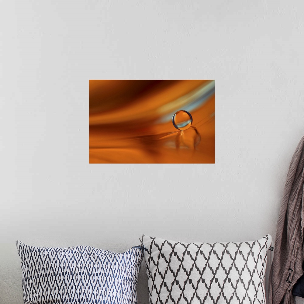 A bohemian room featuring A macro photograph of a water droplet sitting on an orange surface.