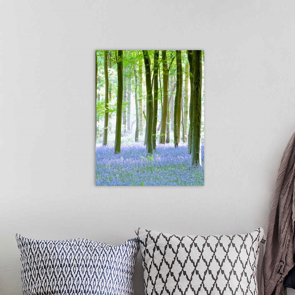 A bohemian room featuring Vertical painting on canvas of a forest with wildflowers sprinkled on the ground beneath them.