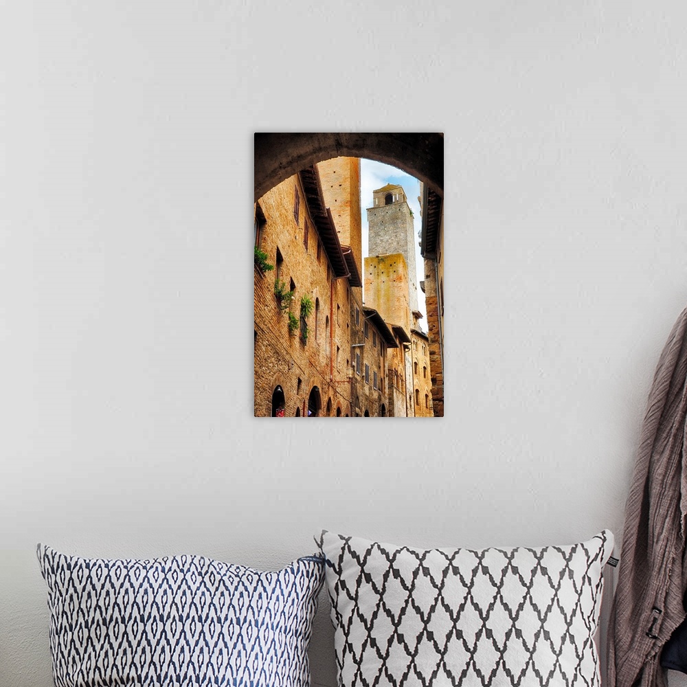 A bohemian room featuring A photograph of stone buildings and tower in Italy.