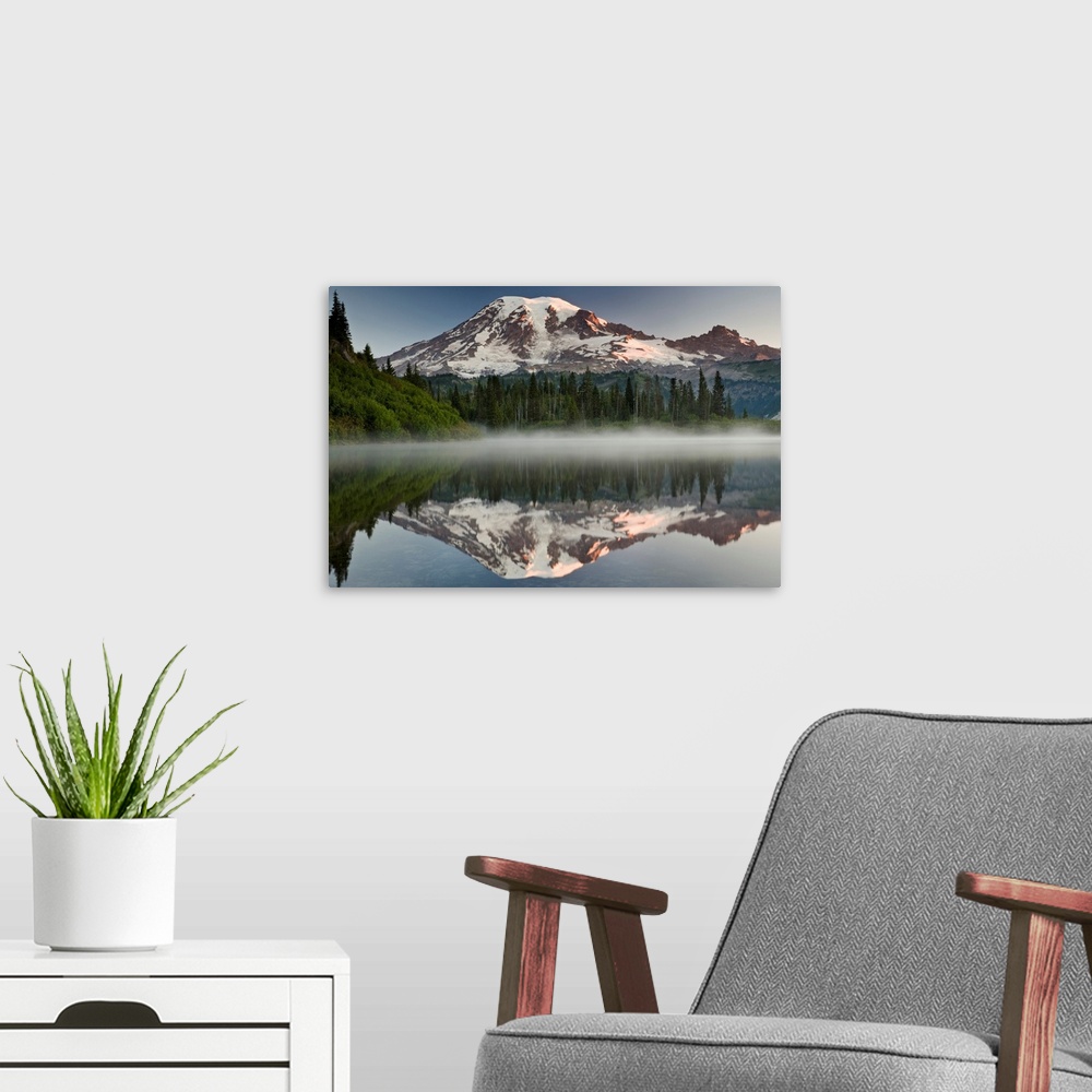 A modern room featuring Big photograph shows the great size of snow-covered Mount Rainier in the background reflecting ov...
